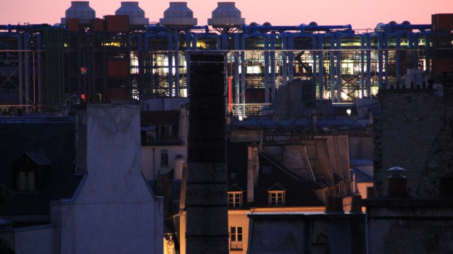 Au premier plan la cheminée restaurée de l'ancienne fonderie d'or et d'argent, au fond le Centre Georges Pompidou. In the foreground the restored chimney of the former gold and silver foundry, in the background the Centre Georges Pompidou.