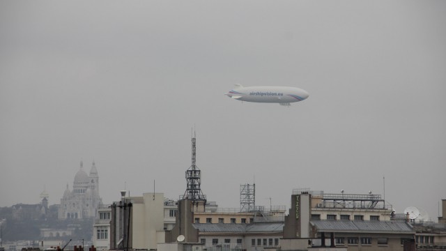 Un dirigeable survole Paris « embrumé ». An airship flies over a foggy Paris.